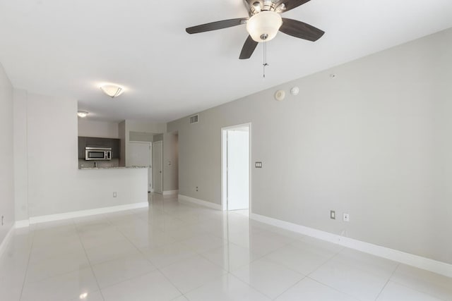 unfurnished room with light tile patterned floors and ceiling fan