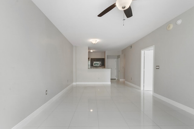 unfurnished living room featuring ceiling fan and light tile patterned floors