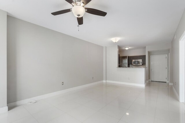 unfurnished living room with ceiling fan and light tile patterned floors