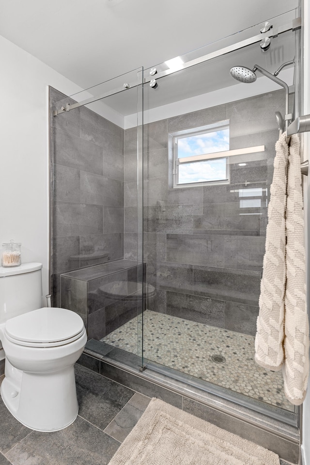 bathroom with walk in shower, tile patterned floors, and toilet