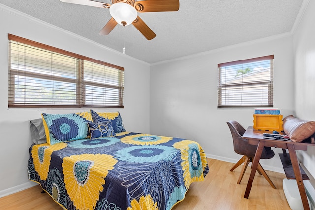 bedroom with ceiling fan, a textured ceiling, crown molding, and hardwood / wood-style floors