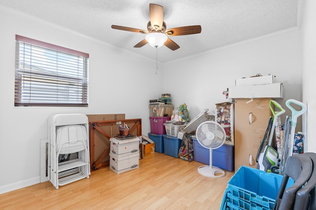 misc room featuring ceiling fan, ornamental molding, a textured ceiling, and light hardwood / wood-style floors