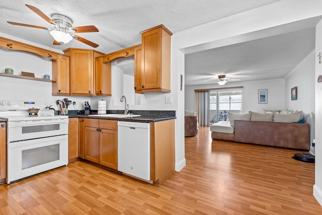 kitchen featuring white appliances, sink, ceiling fan, and light hardwood / wood-style flooring