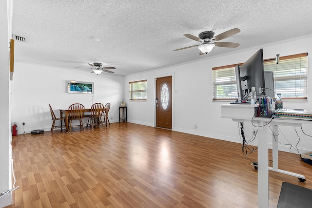 office space with ceiling fan, a textured ceiling, and light wood-type flooring