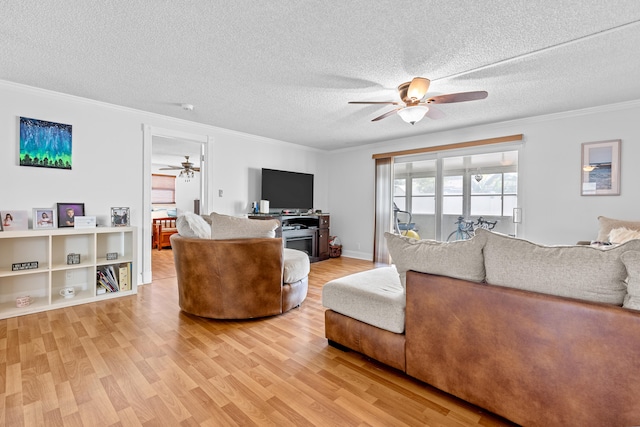 living room featuring ornamental molding, ceiling fan, hardwood / wood-style flooring, and a textured ceiling