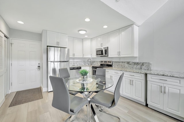 dining space featuring sink and light wood-type flooring