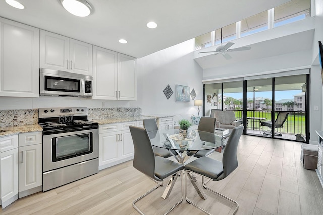 kitchen featuring white cabinetry, stainless steel appliances, and light stone countertops