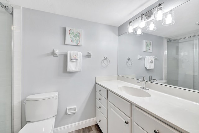 bathroom featuring wood-type flooring, vanity, walk in shower, toilet, and a textured ceiling