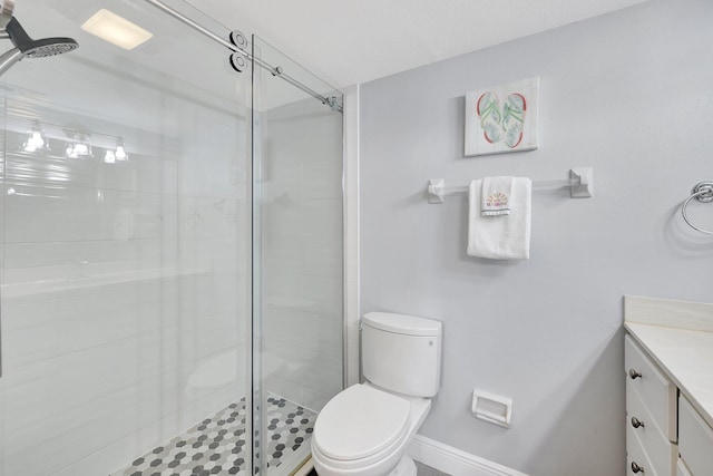 bathroom featuring vanity, an enclosed shower, and toilet