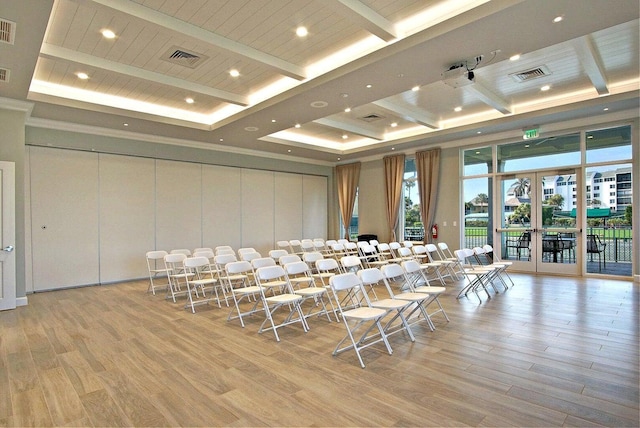 home theater featuring a high ceiling, light hardwood / wood-style floors, and french doors