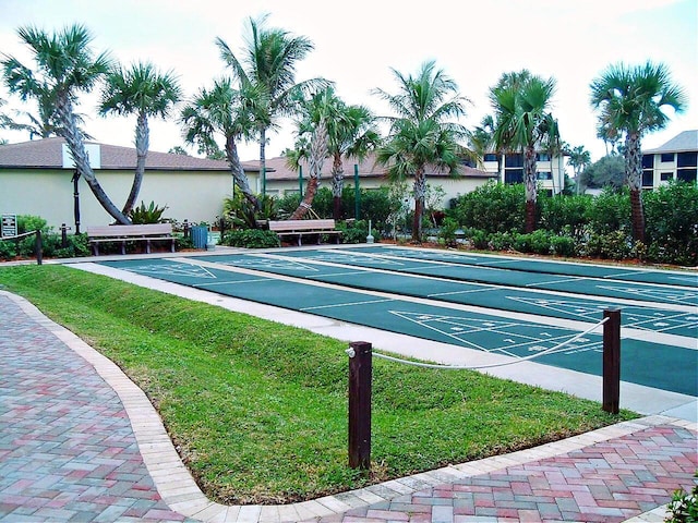 view of home's community with shuffleboard and a lawn