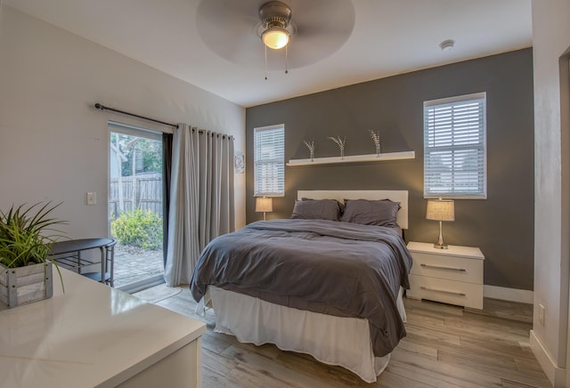 bedroom with light wood-style flooring, access to exterior, a ceiling fan, and baseboards