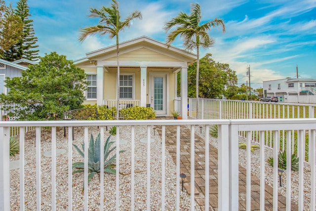 view of front of house with a porch, fence, and stucco siding