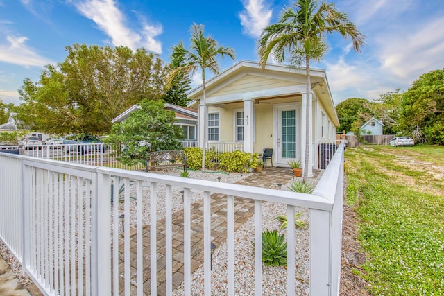view of front of house featuring a porch, a fenced front yard, and stucco siding