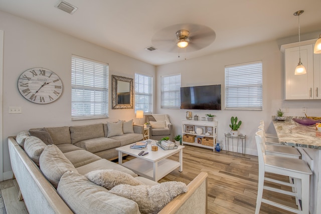 living room with light hardwood / wood-style flooring and ceiling fan