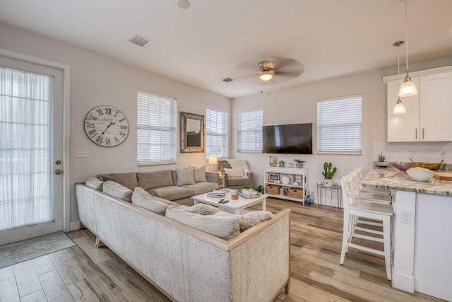 living room featuring light hardwood / wood-style floors and ceiling fan