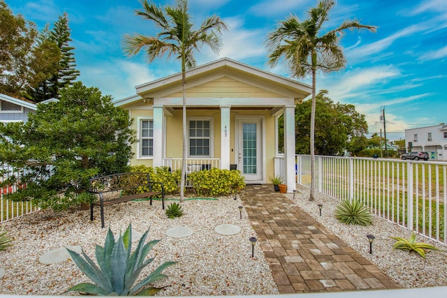 view of front of home featuring stucco siding, fence, and covered porch