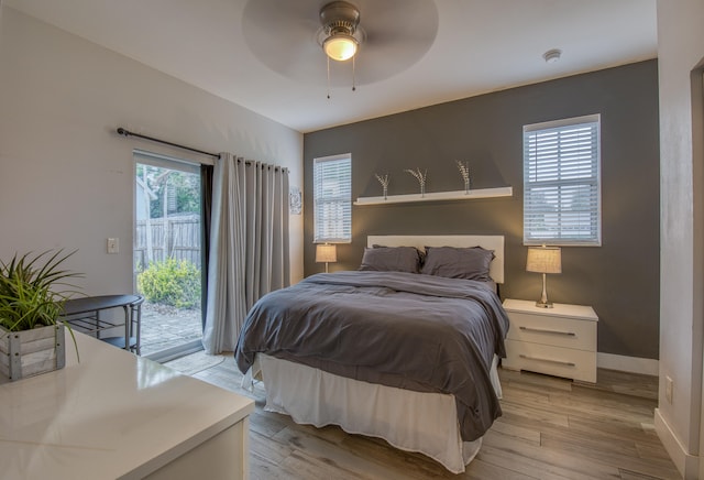 bedroom featuring multiple windows, access to outside, ceiling fan, and light hardwood / wood-style flooring