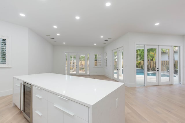 kitchen featuring french doors, a center island, white cabinetry, and a healthy amount of sunlight