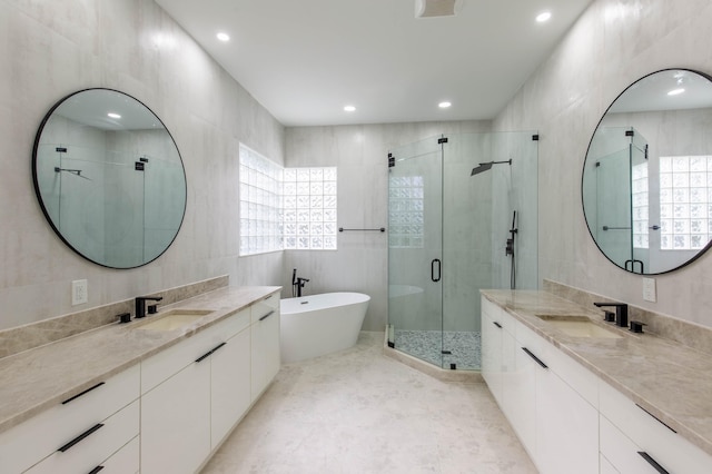 bathroom with vanity, tile walls, and shower with separate bathtub