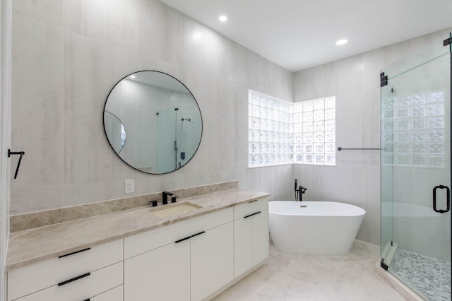 bathroom with tile walls and shower with separate bathtub