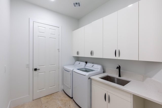 laundry room with washer and dryer, cabinets, and sink