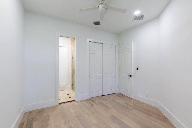 unfurnished bedroom featuring connected bathroom, ceiling fan, a closet, and light hardwood / wood-style floors