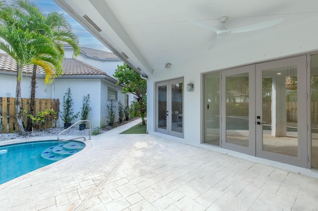 view of swimming pool with a patio area, ceiling fan, and french doors