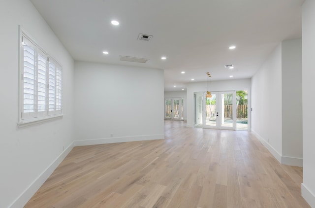 spare room with french doors and light wood-type flooring