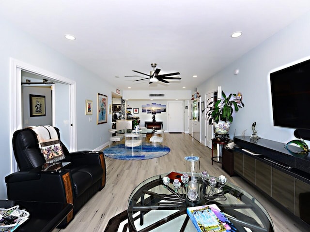 living room with light hardwood / wood-style flooring and ceiling fan