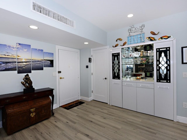 entrance foyer with indoor bar and hardwood / wood-style floors