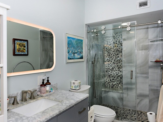 bathroom featuring vanity, toilet, and an enclosed shower