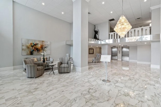 interior space featuring an inviting chandelier, a high ceiling, and elevator