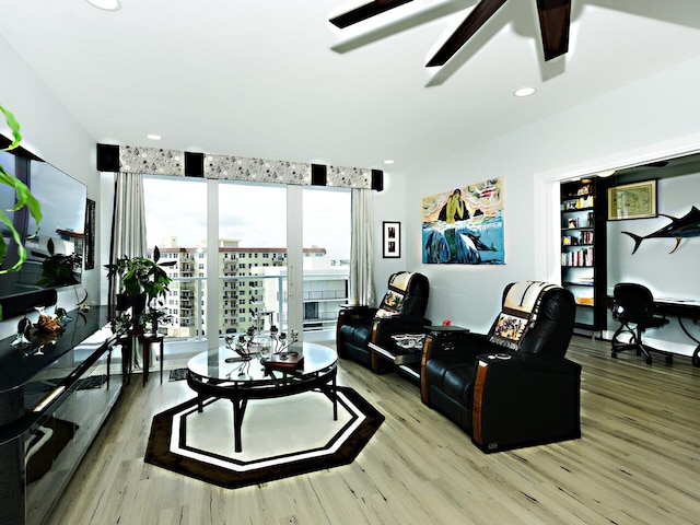 living room featuring ceiling fan and hardwood / wood-style floors