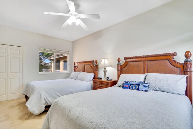 carpeted bedroom featuring ceiling fan and a closet