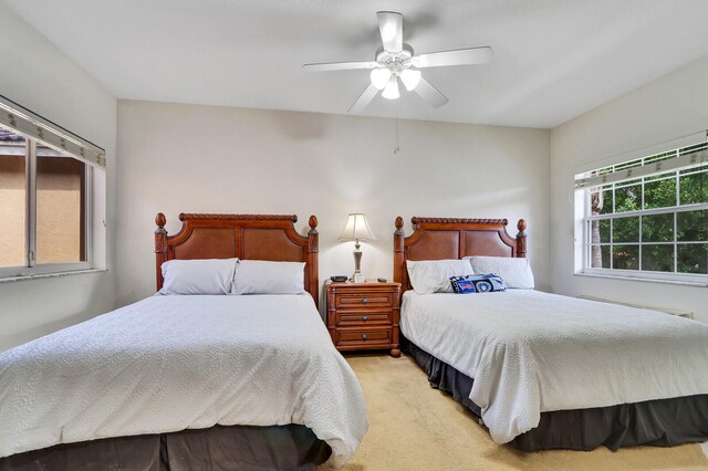 bedroom featuring light carpet and ceiling fan