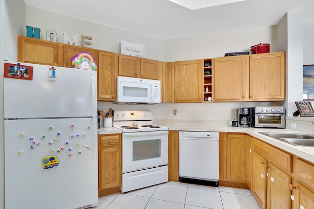 kitchen featuring sink, light tile patterned floors, and white appliances