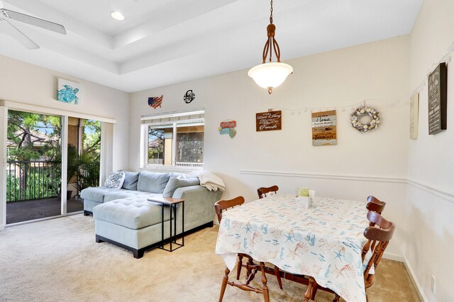 carpeted dining area with ceiling fan