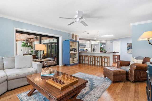 living room featuring ornamental molding, ceiling fan, and light hardwood / wood-style flooring