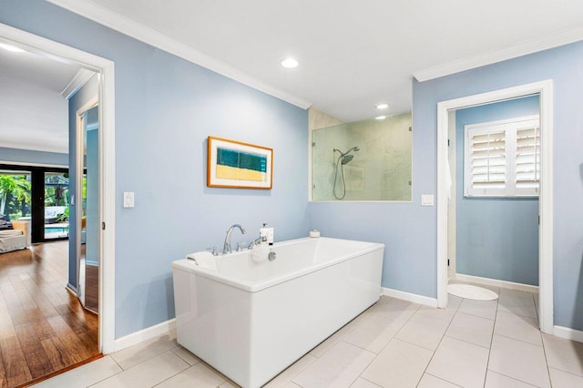 bathroom with independent shower and bath, a healthy amount of sunlight, ornamental molding, and wood-type flooring