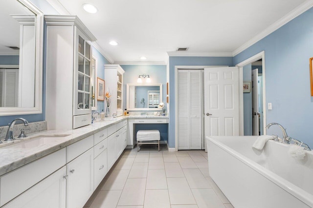 bathroom with vanity, a tub to relax in, crown molding, and tile patterned flooring