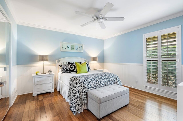 bedroom with ornamental molding, ceiling fan, and hardwood / wood-style floors