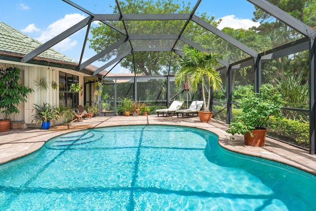 view of swimming pool featuring a patio and a lanai