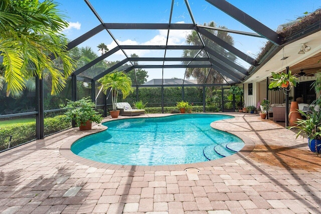 view of pool with a lanai, a patio, and ceiling fan