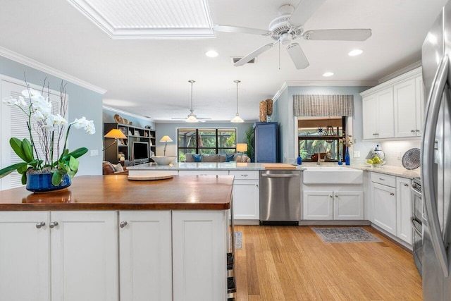 kitchen with ceiling fan, stainless steel appliances, white cabinetry, and wood counters