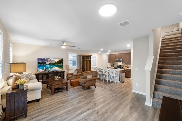 living room with light wood-type flooring and ceiling fan