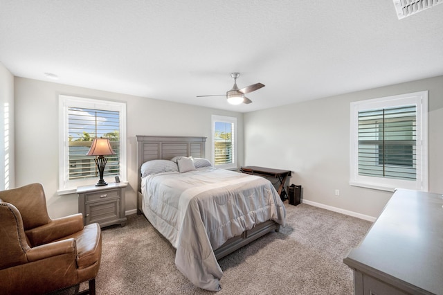 bedroom featuring multiple windows, ceiling fan, and light colored carpet