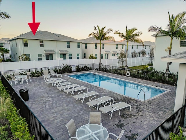 pool at dusk featuring a patio