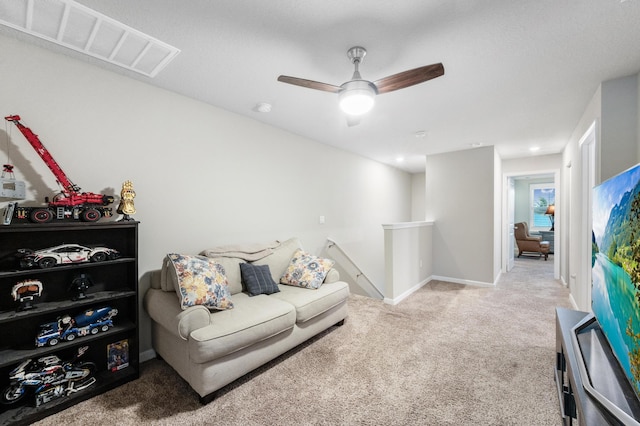 carpeted living room with ceiling fan