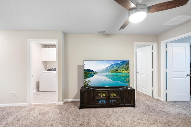 carpeted living room featuring washer / dryer and ceiling fan